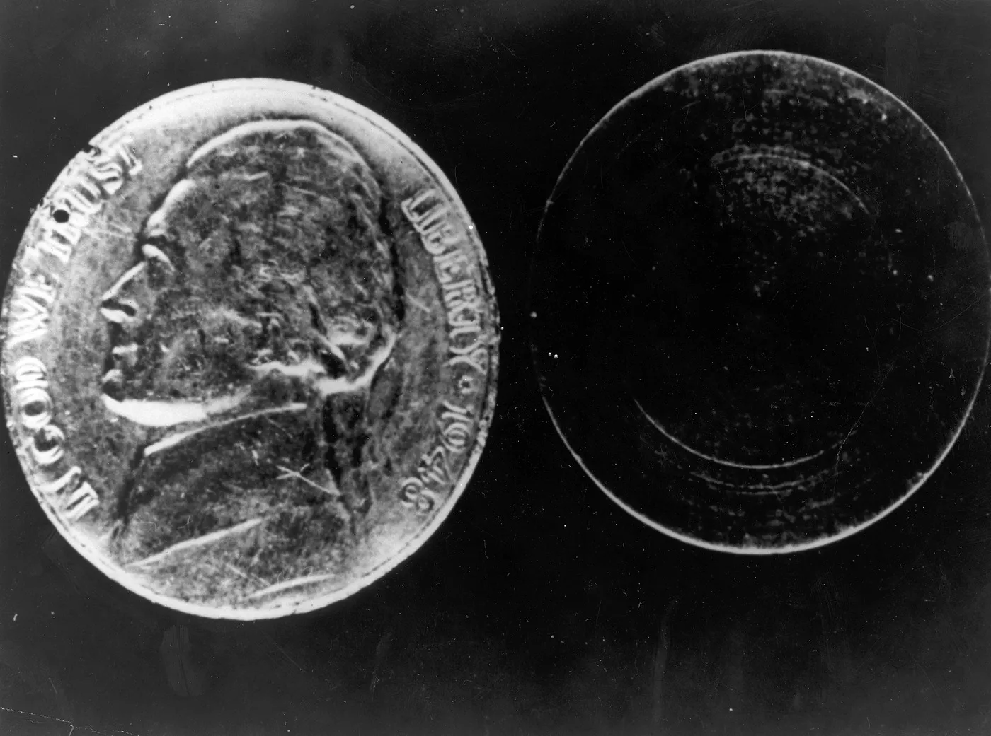 Two separated halves of the actual hollow nickel, photographed against a dark background.